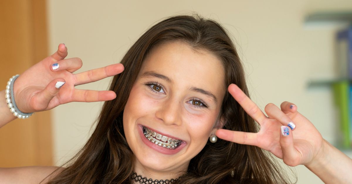 Close-up of a young child's smile with colourful dental braces